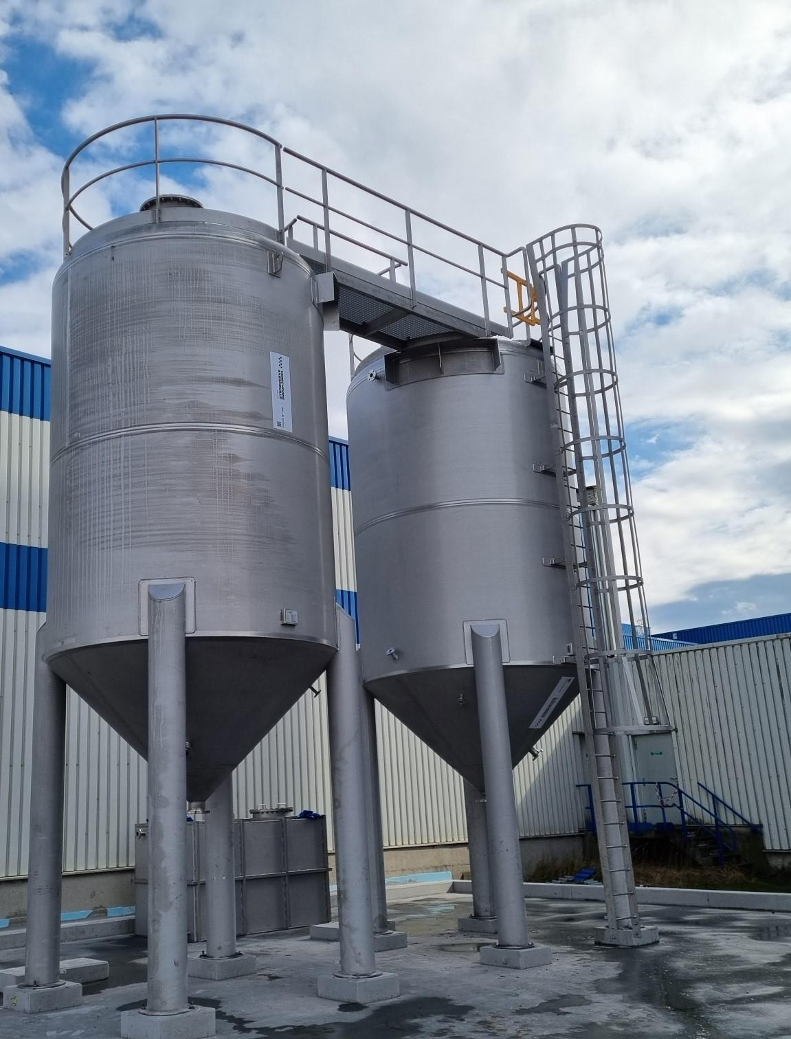 2 silo\'s in INOX 316 L, voor de opslag van specifieke hydraulische olie, voorzien van een roerwerk om het product in beweging te houden.